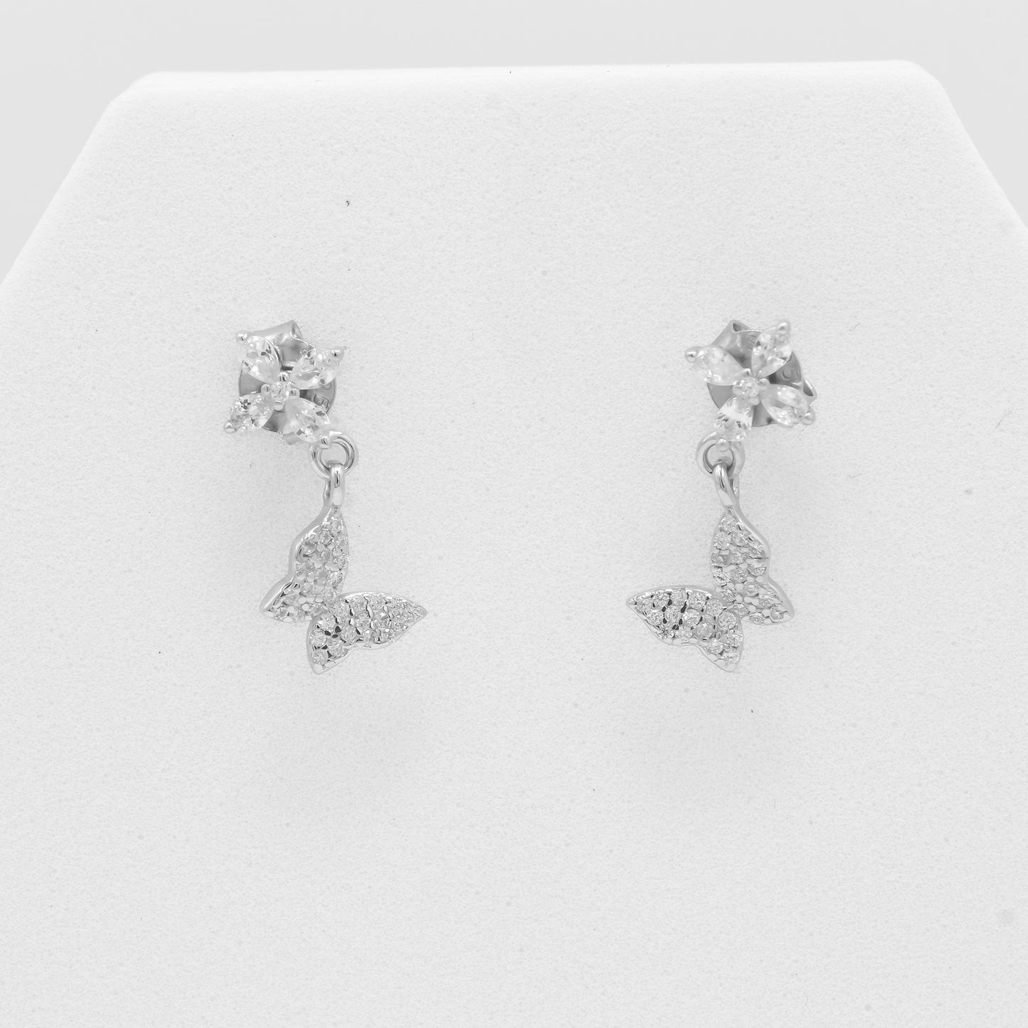 Close-up of Zyrene 925 silver floral earrings with butterfly charm detailing