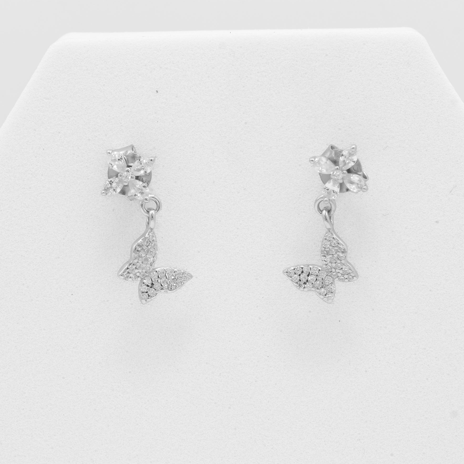 Close-up of Zyrene 925 silver floral earrings with butterfly charm detailing