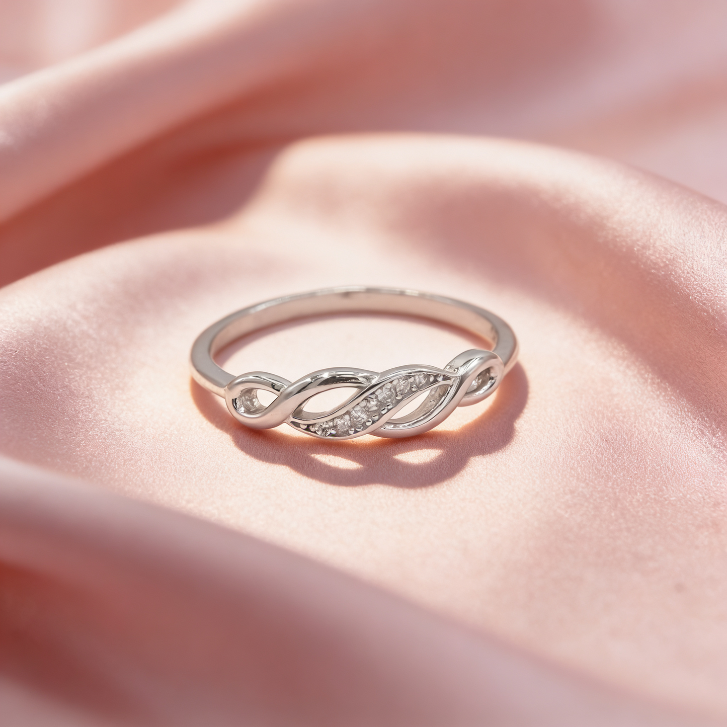 Leher 925 silver infinity braid ring for women by Zyrene on pink satin background