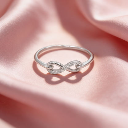 Noor 925 silver infinity loop ring for women by Zyrene on pink satin background
