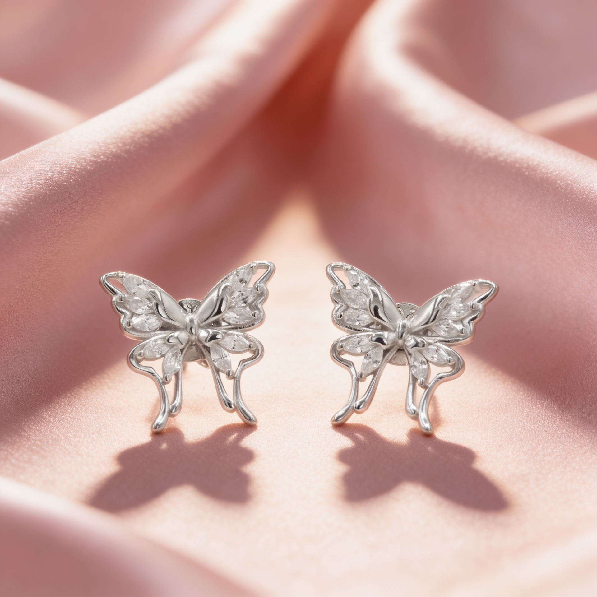 925 silver butterfly earrings for women by Zyrene on pink satin background