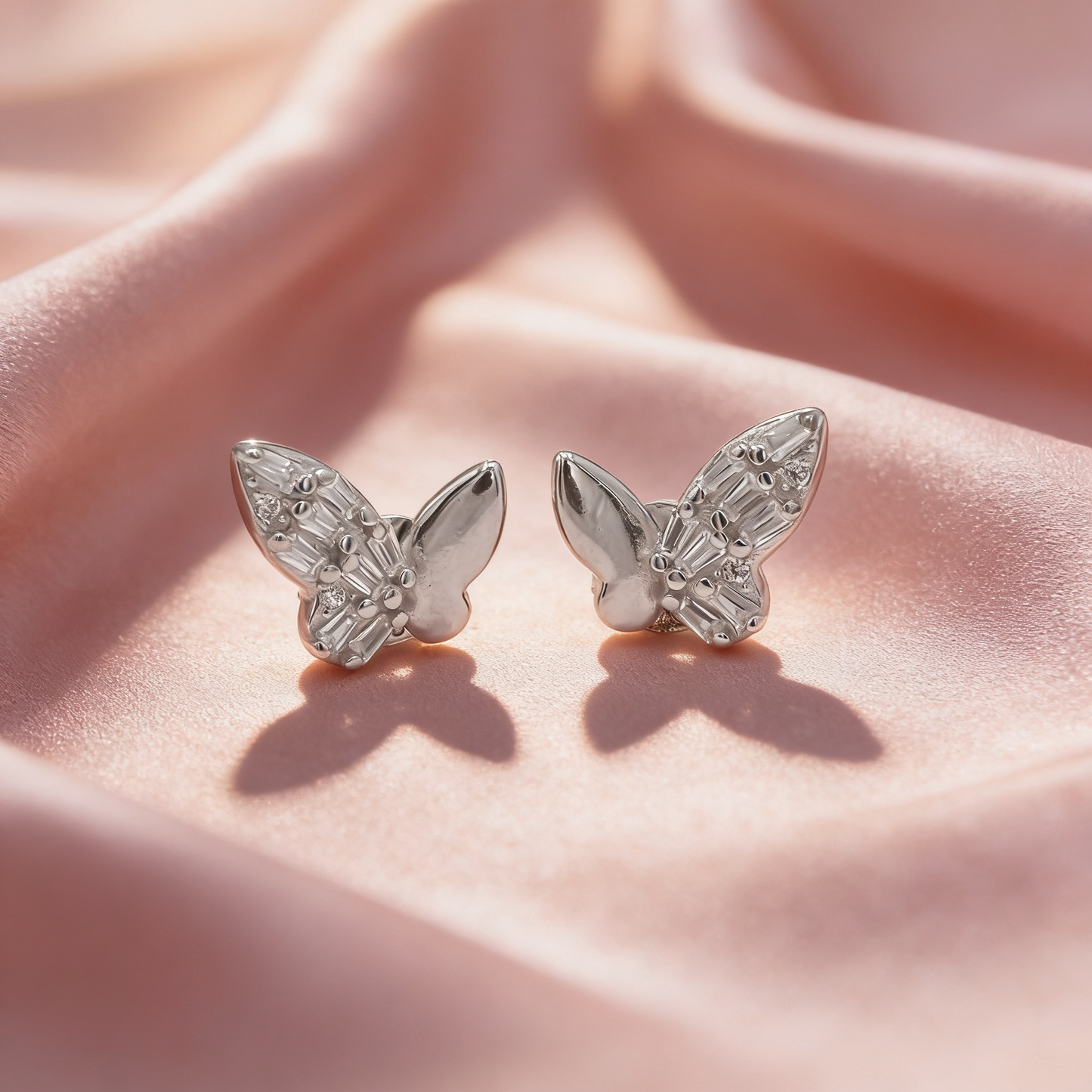 925 silver crystal butterfly earrings for women by Zyrene on pink satin background
