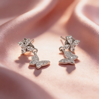 925 silver floral butterfly earrings for women by Zyrene on pink satin background