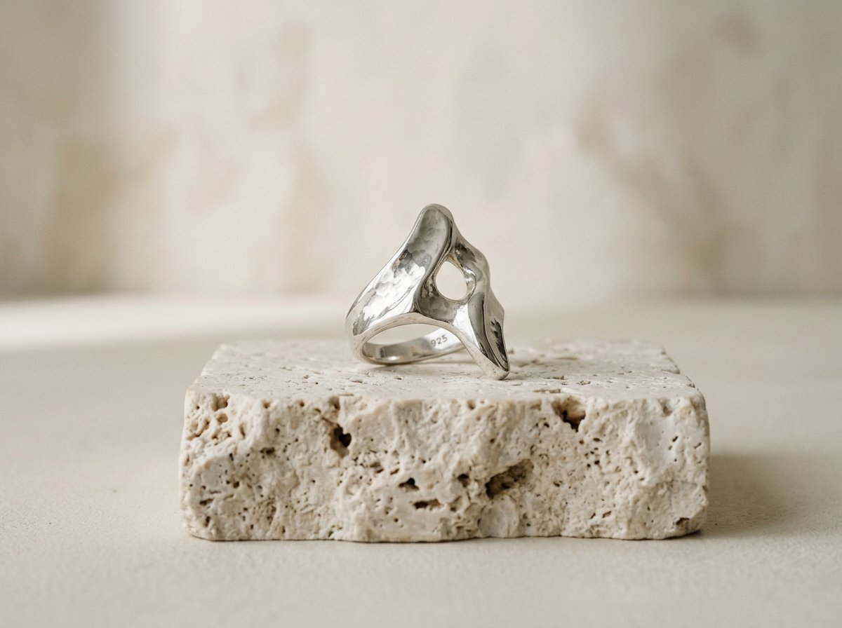 Contemporary sculptural silver ring by Zyrene on neutral stone
